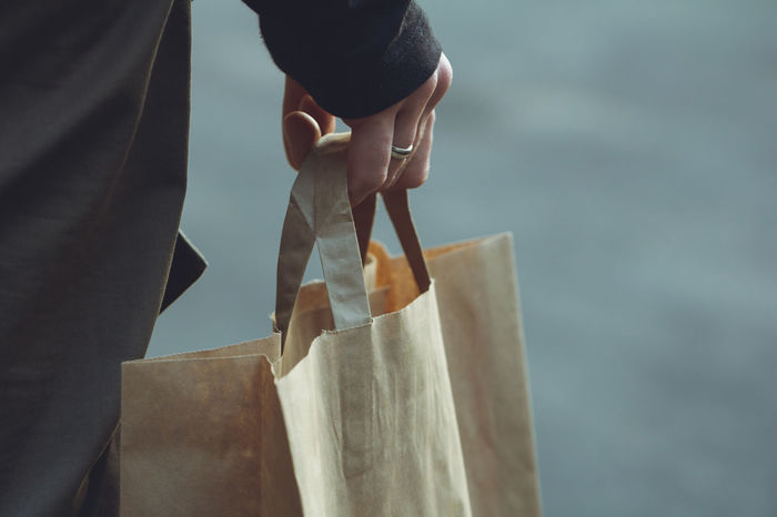 Midsection of person holding shopping bag