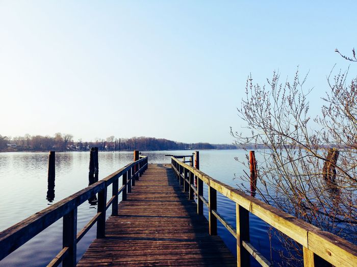 Wooden pier over sea against clear sky