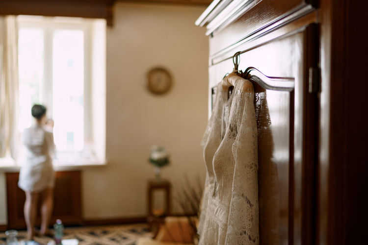 MIDSECTION OF WOMAN STANDING AT HOME