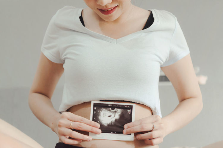 Midsection of woman holding camera
