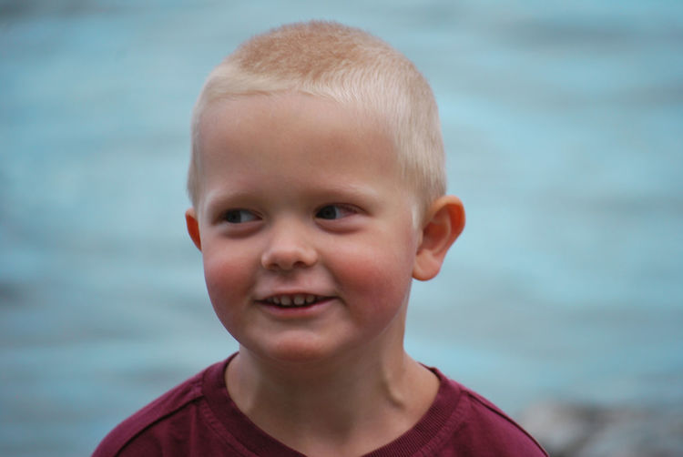 Close-up of smiling boy looking away