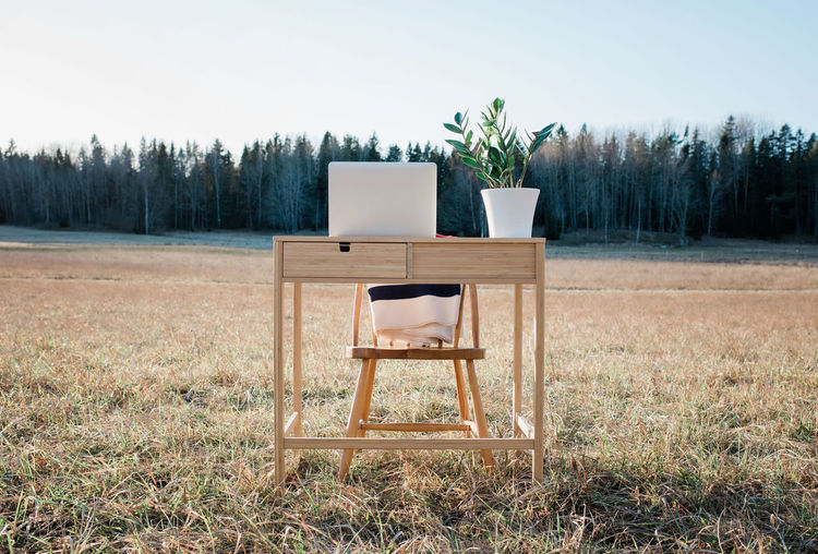 A desk and laptop home office in the middle of a field outdoors