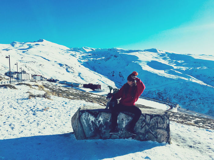 Man sitting on snow covered mountain