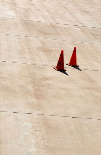 High angle view of traffic cones at concrete runway on sunny day