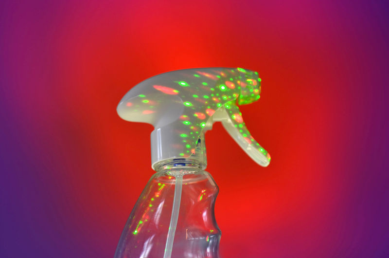 Close-up of glass bottle against red background