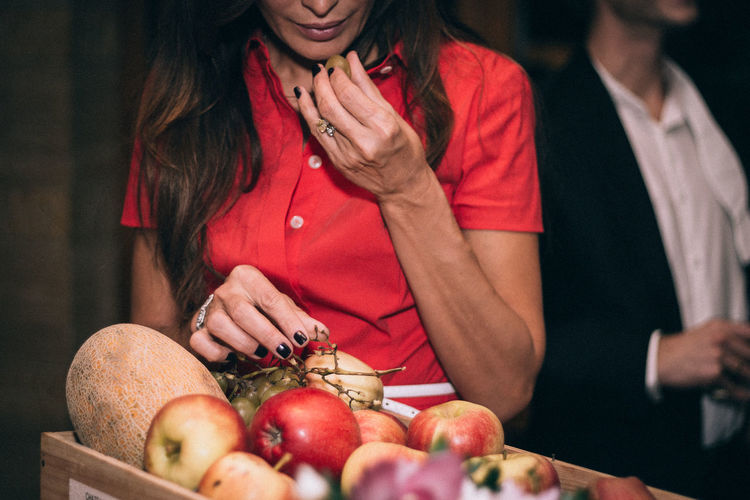 Midsection of woman holding grape