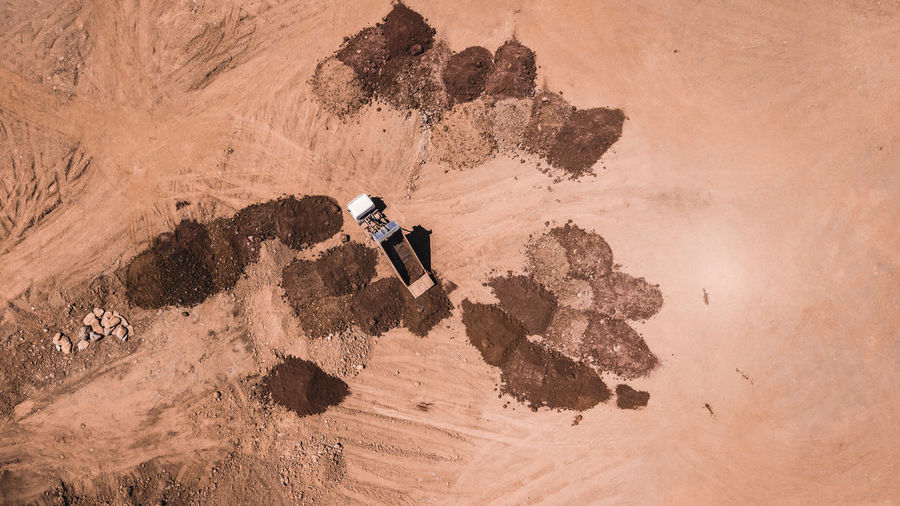 Truck unloading earth on a pile. aerial shot