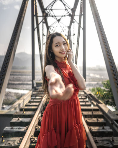 Portrait of woman standing on railroad bridge