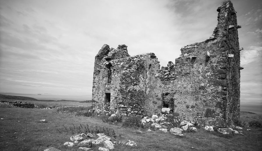 Old ruin building on field against sky
