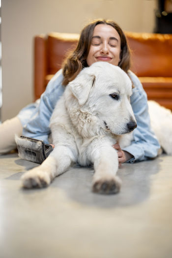 Portrait of woman with dog relaxing at home