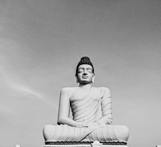 Portrait of a gauthama buddha sitting against wall