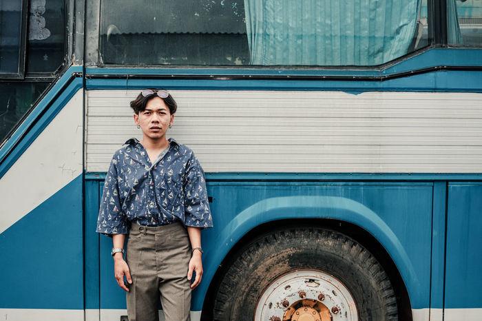 Portrait of man standing against bus