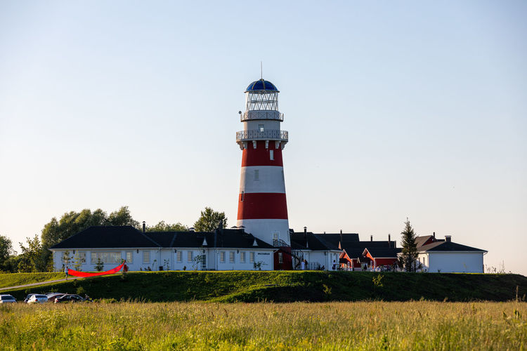 Lighthouse in red and white colors on the seashore, river bank or lake shore. lighthouse hotel.