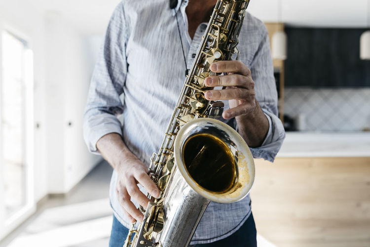 Musician practicing saxophone at home