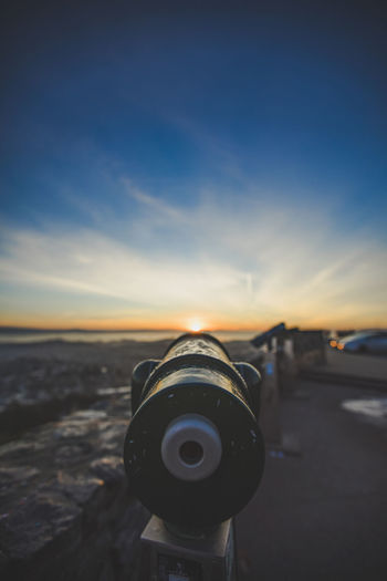 Close-up of telescope against sky during sunset