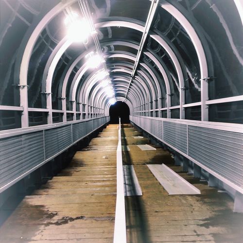 Man walking on footbridge in tunnel