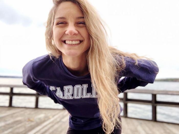 Portrait of smiling young woman with blond hair standing on pier