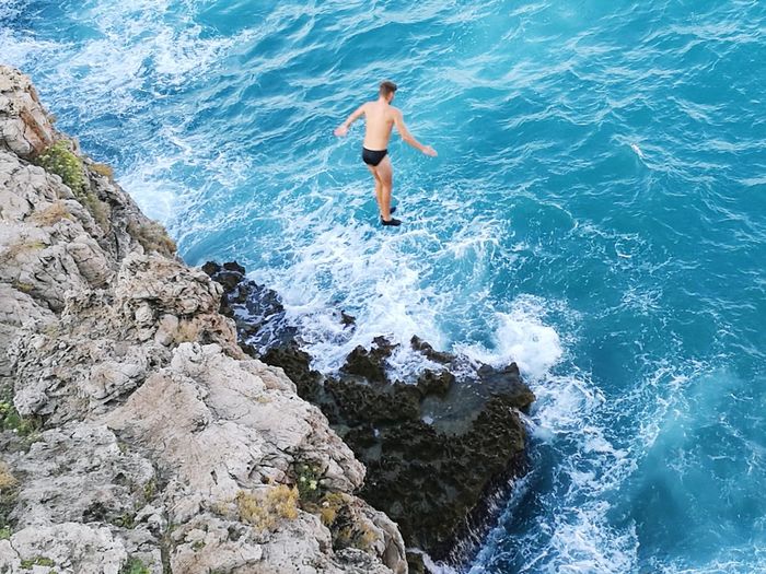 High angle view of man jumping in sea