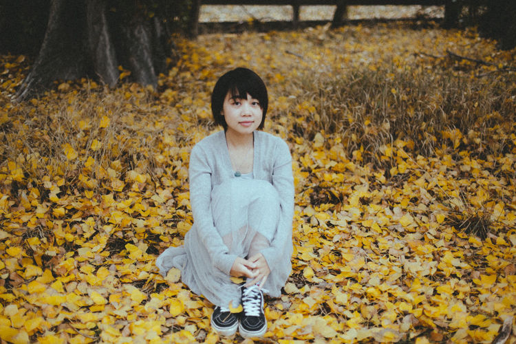 Portrait of young woman sitting on ground