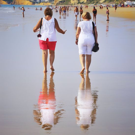 Rear view of women walking on beach