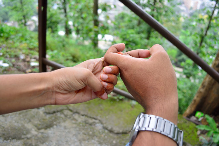 Cropped image of couple holding hands in park