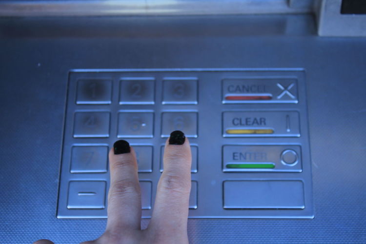 Cropped image of woman operating atm machine