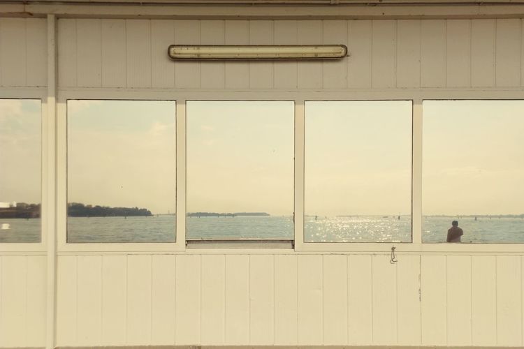 Scenic view of sea against sky seen through window