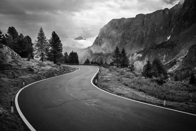 Road amidst trees against sky
