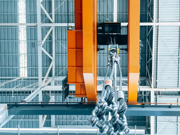 Overhead crane and machine inside factory building, industrial background.