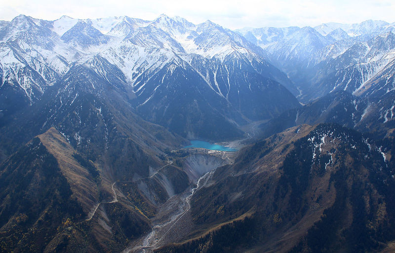 Top view of an alpine lake in a mountain gorge with peaks in the snow