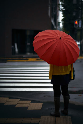 Rear view of woman with umbrella walking in rain