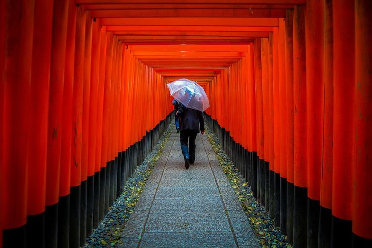 Rear view of man walking on footpath