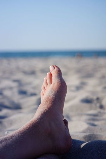 Low section of person relaxing on beach