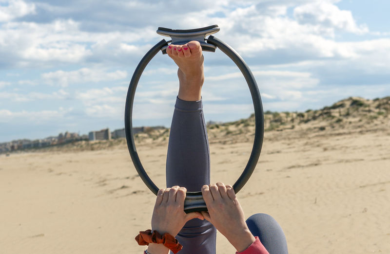 Photo of pilates ring with female hands and foot