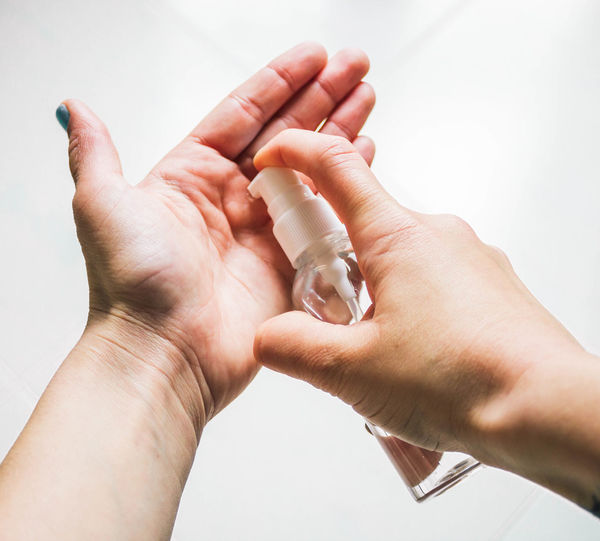 Female hands applying hand sanitizer gel