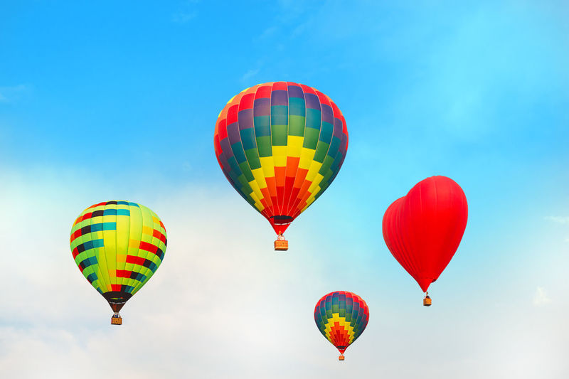 Four bright multicolored balloons against the blue sky