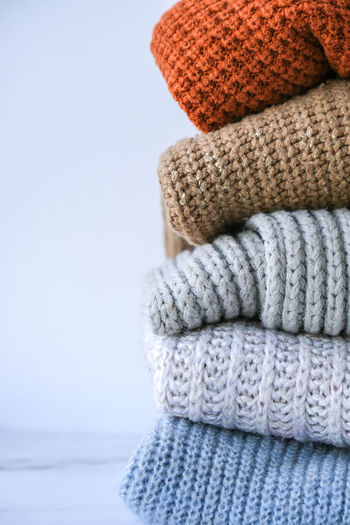 Stack of cozy knitted warm sweater. sweaters in retro style. orange and blue colors. cozy hygge 