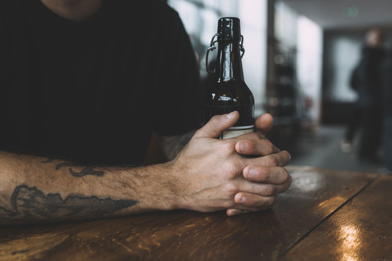 Close-up of man holding beer bottle