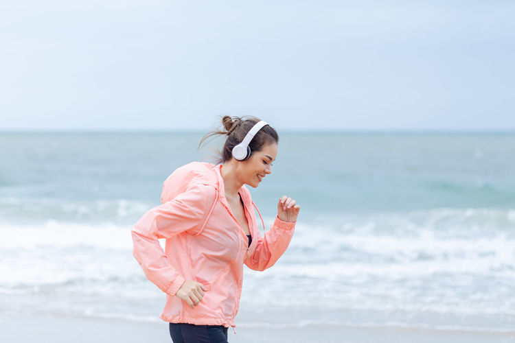 Rear view of woman standing at beach
