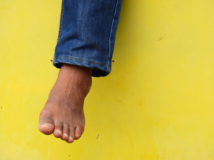 Low section of man against yellow wall