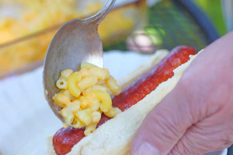Man adds macaroni and cheese to hot dog