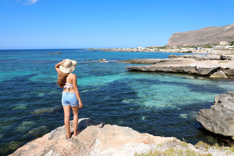 Young woman enjoying vacation in favignana island, sicily, italy.