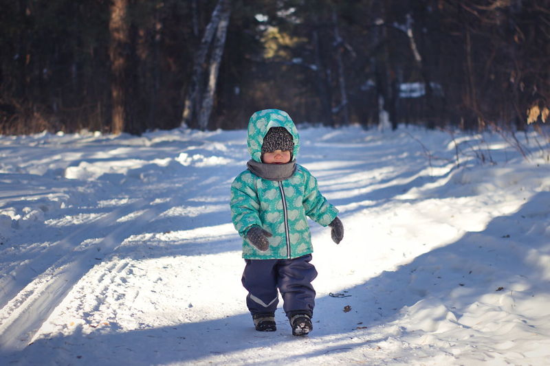 Full length of girl walking on snow covered land