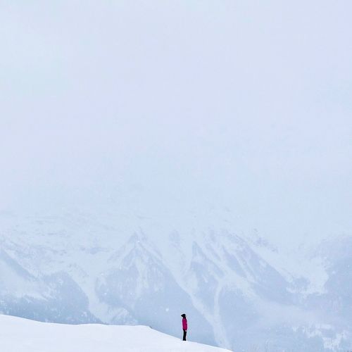 Person on snow covered mountain against sky