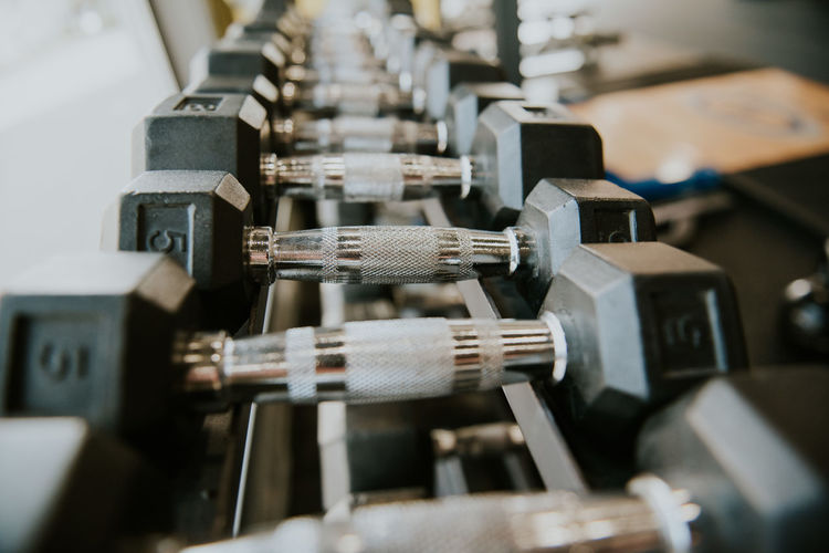 Close-up of dumbbells on shelf in gym