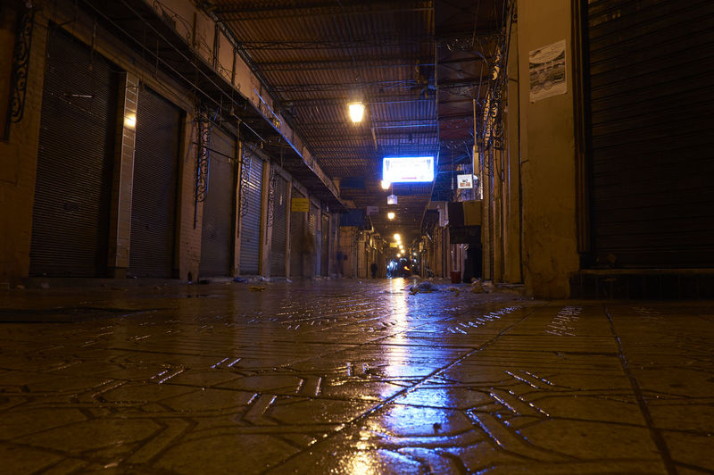 Illuminated walkway in city at night