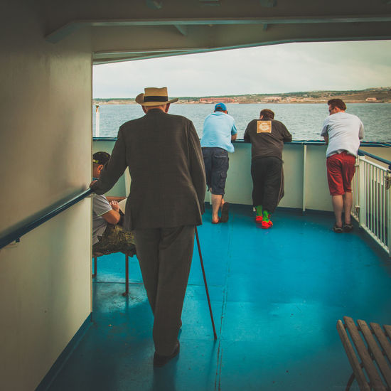 Rear view of people standing on ship