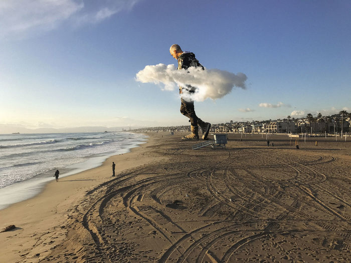 Digital composite image of huge man at beach