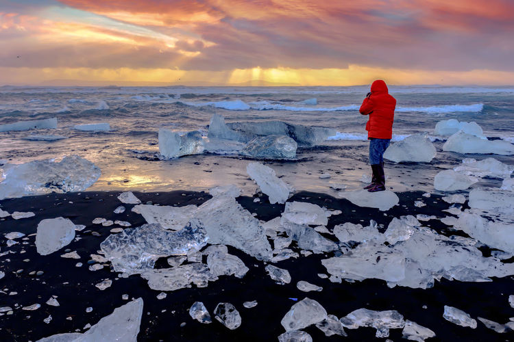 Full length of man standing on ice during sunset