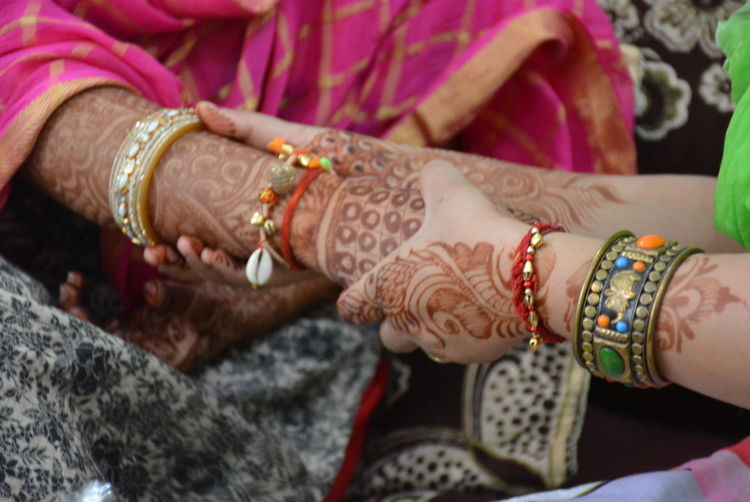 Cropped image of woman assisting friend in wearing bangles